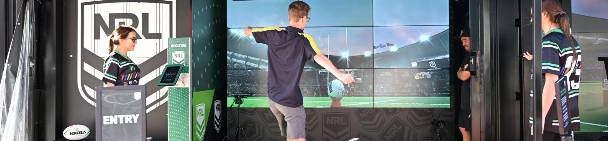 Photo of young people interacting with a virtual reality NRL ball and goal